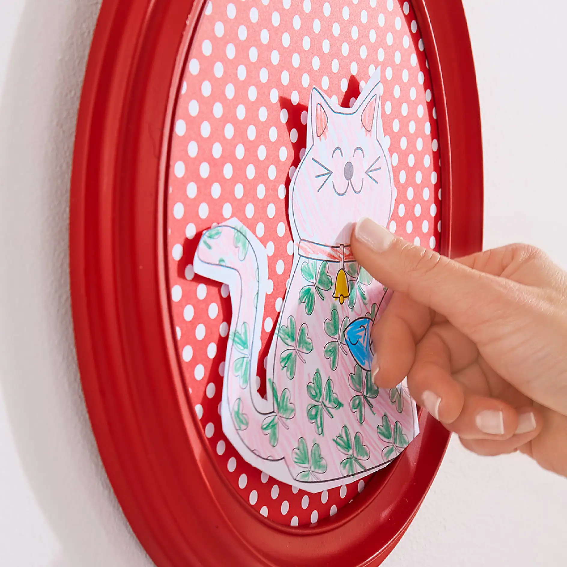 在用透明玻璃用双面粘胶垫来制作手工制作艺术墙时,将儿童的艺术作品固定在相框内。