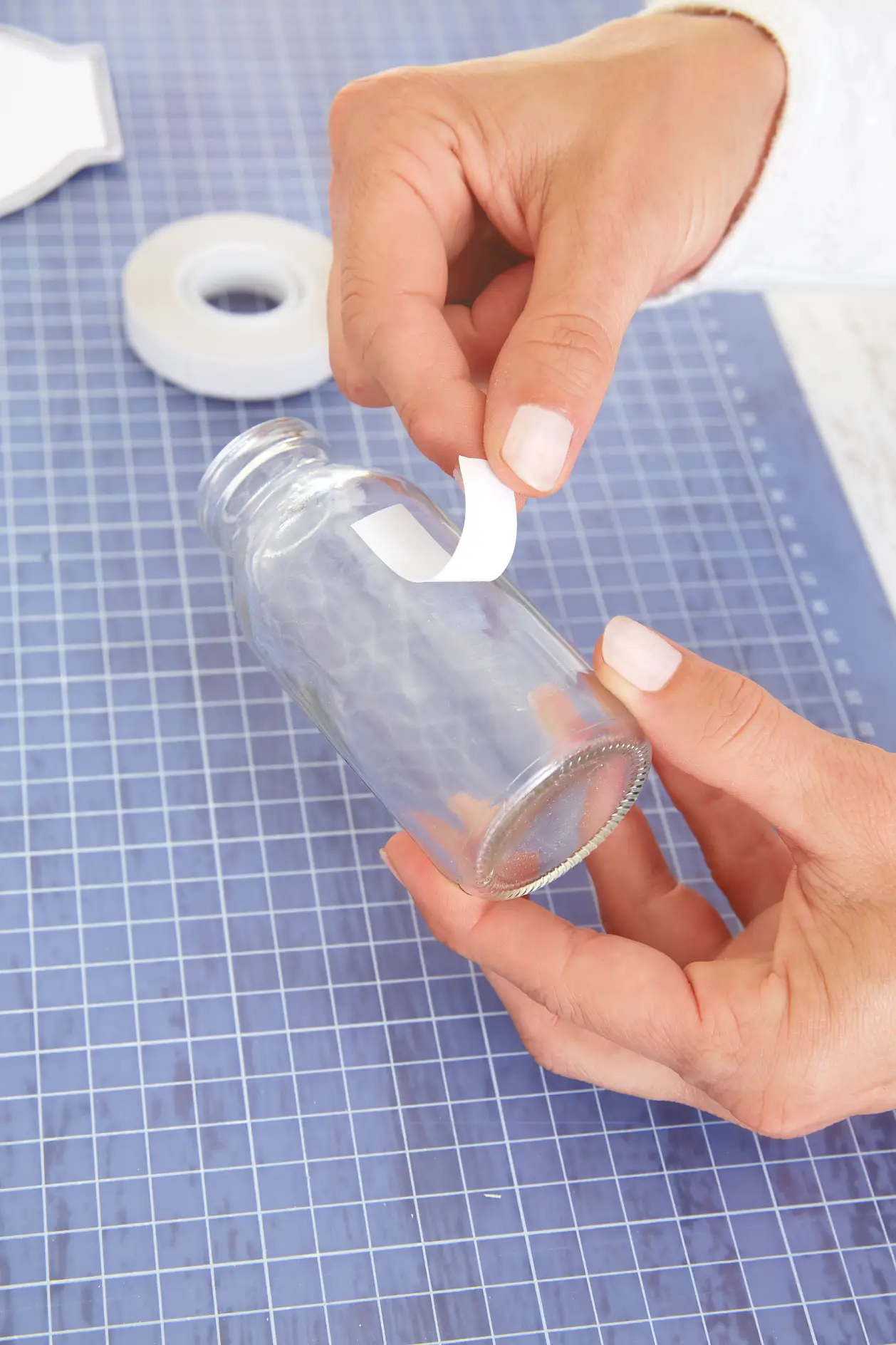 将一条tesa®双面胶带粘接到玻璃花瓶上。 撕下保护膜。