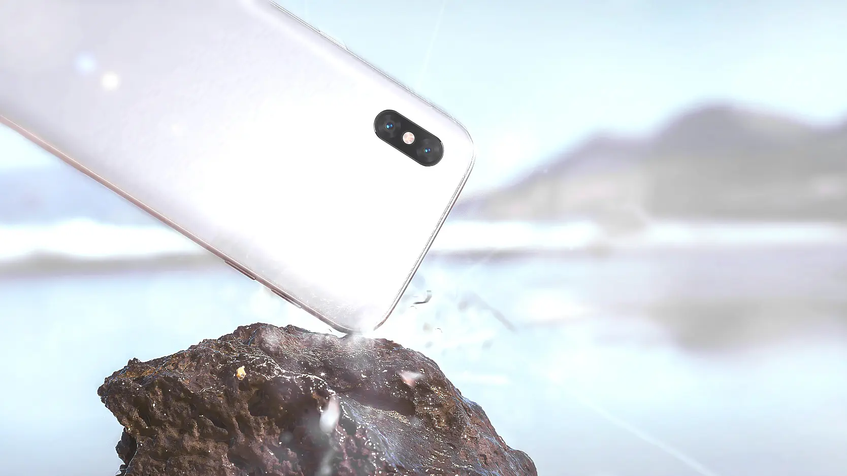 A smartphone is captured mid-air, splashing water as it drops towards a rocky surface. The background features a blurred landscape with mountains and a body of water. (This text has been generated by AI)