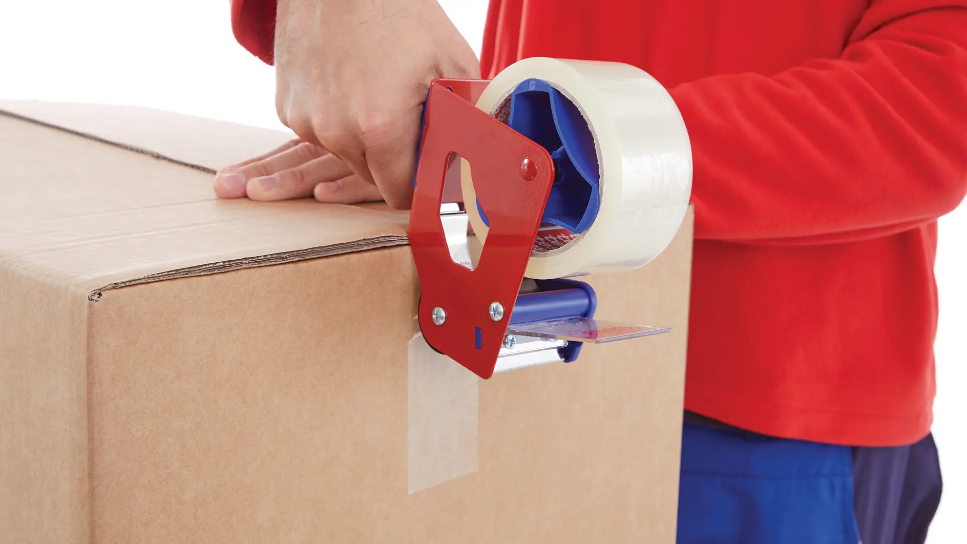 person in red shirt sealing cardboard box with clear packing tape dispenser indoors